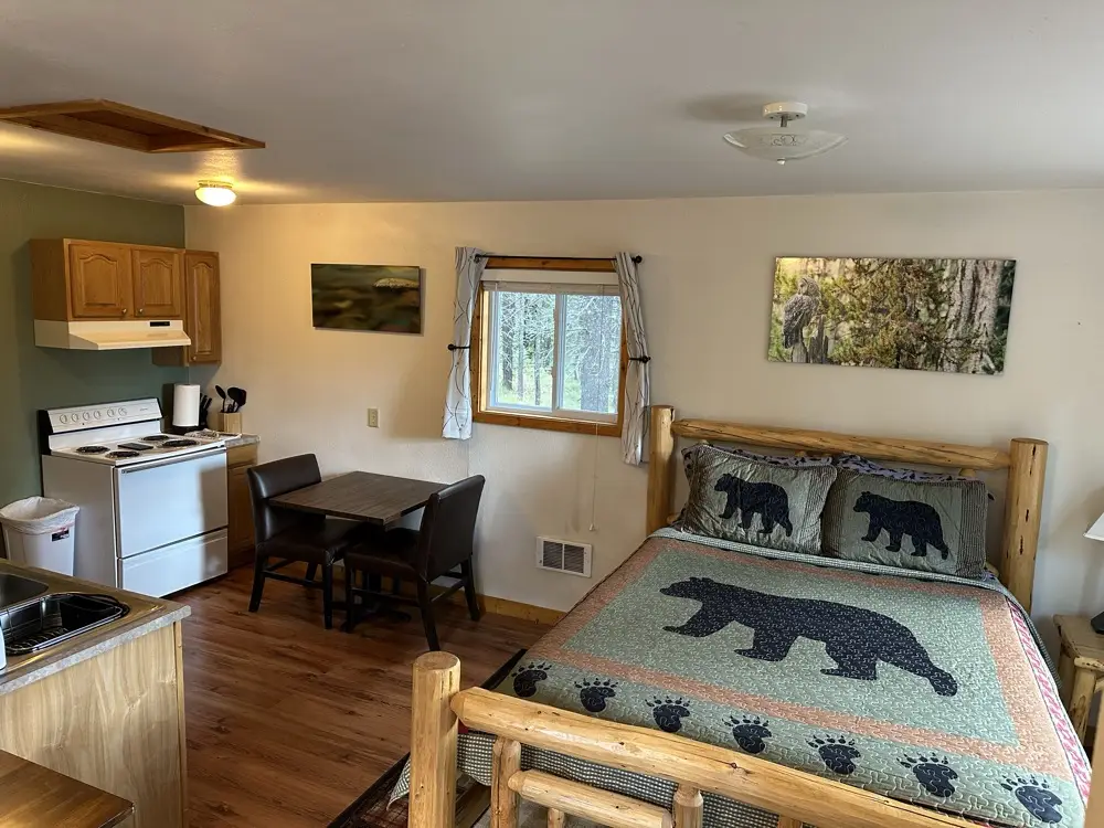 Full kitchenette with stove and dining area inside the Lone Walker cabin